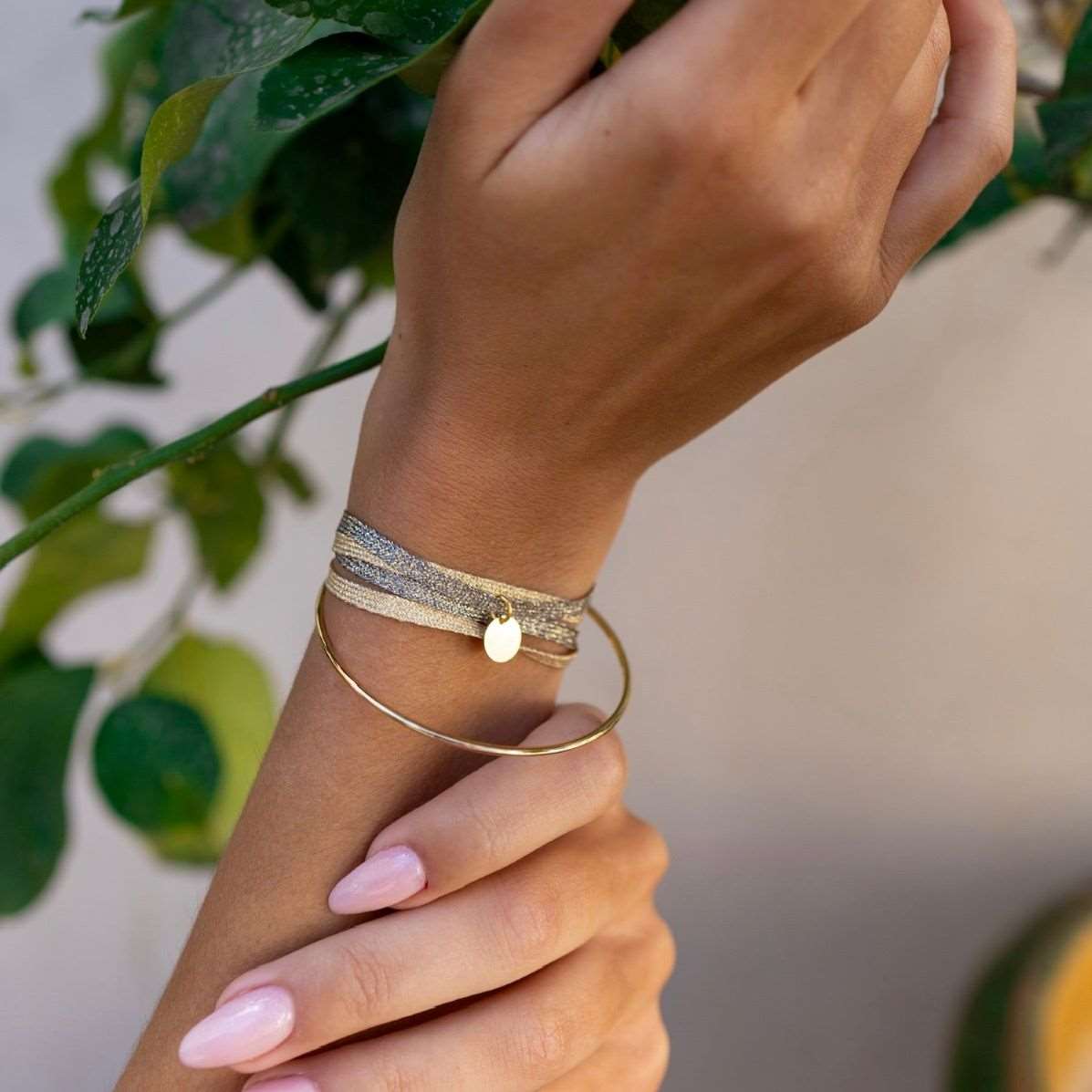 Poignet de femme portant un bracelet élégant avec une médaille  