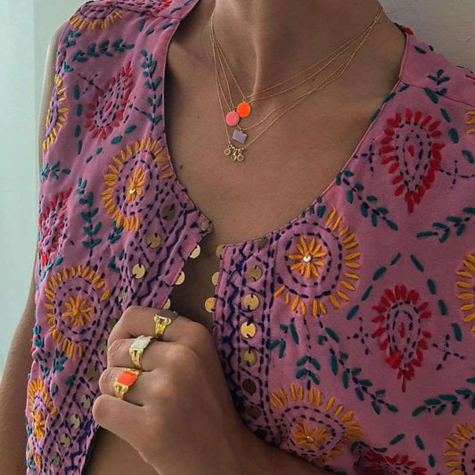 Buste de femme indienne portant un collier avec un médaillon couleur corail et des bagues en or